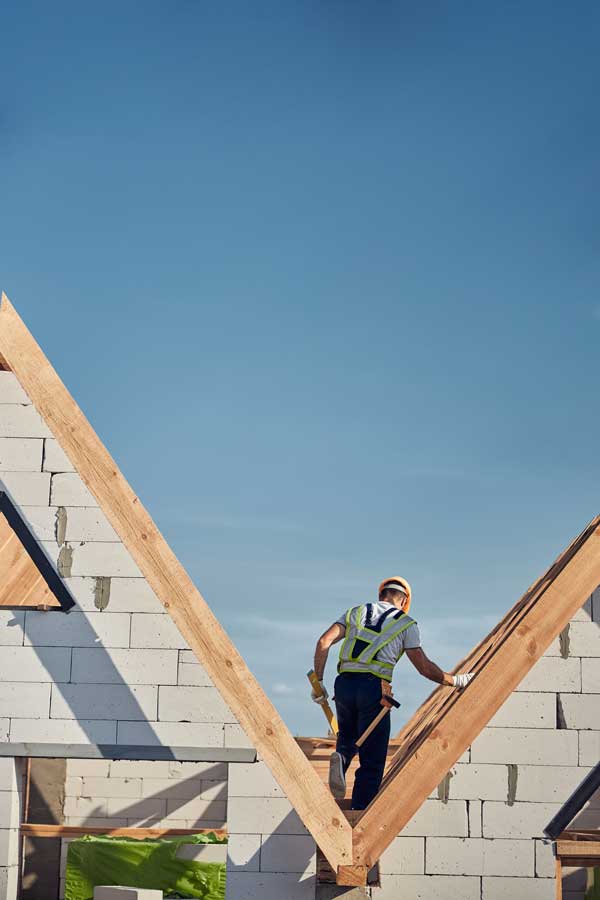 construction builder walking on top of housing structure